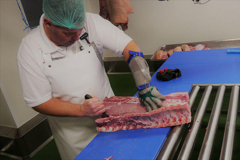 Mitarbeiter des FZK zerlegt ein Fleischstück