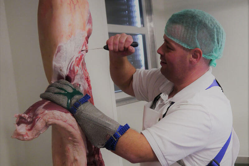 Mitarbeiter des FZK zerlegt ein Fleischstück